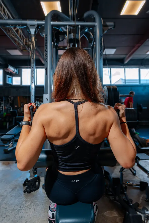 A lifter on the lat pulldown, back in focus