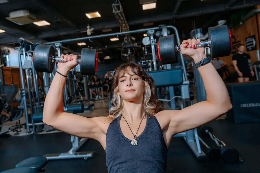 A lifter doing a dumbbell shoulder press