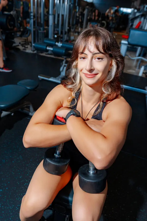 Smiling lifter holding dumbbells